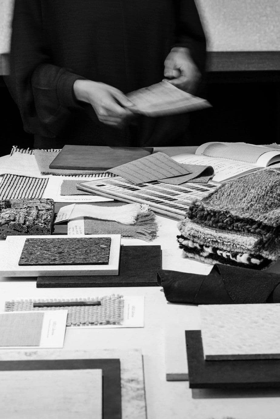 Material library table covered in fabric swatches and sample cards